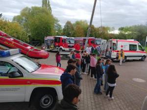 Diverse Fahrzeuge von Hilfsorganisationen auf dem Pausenhof